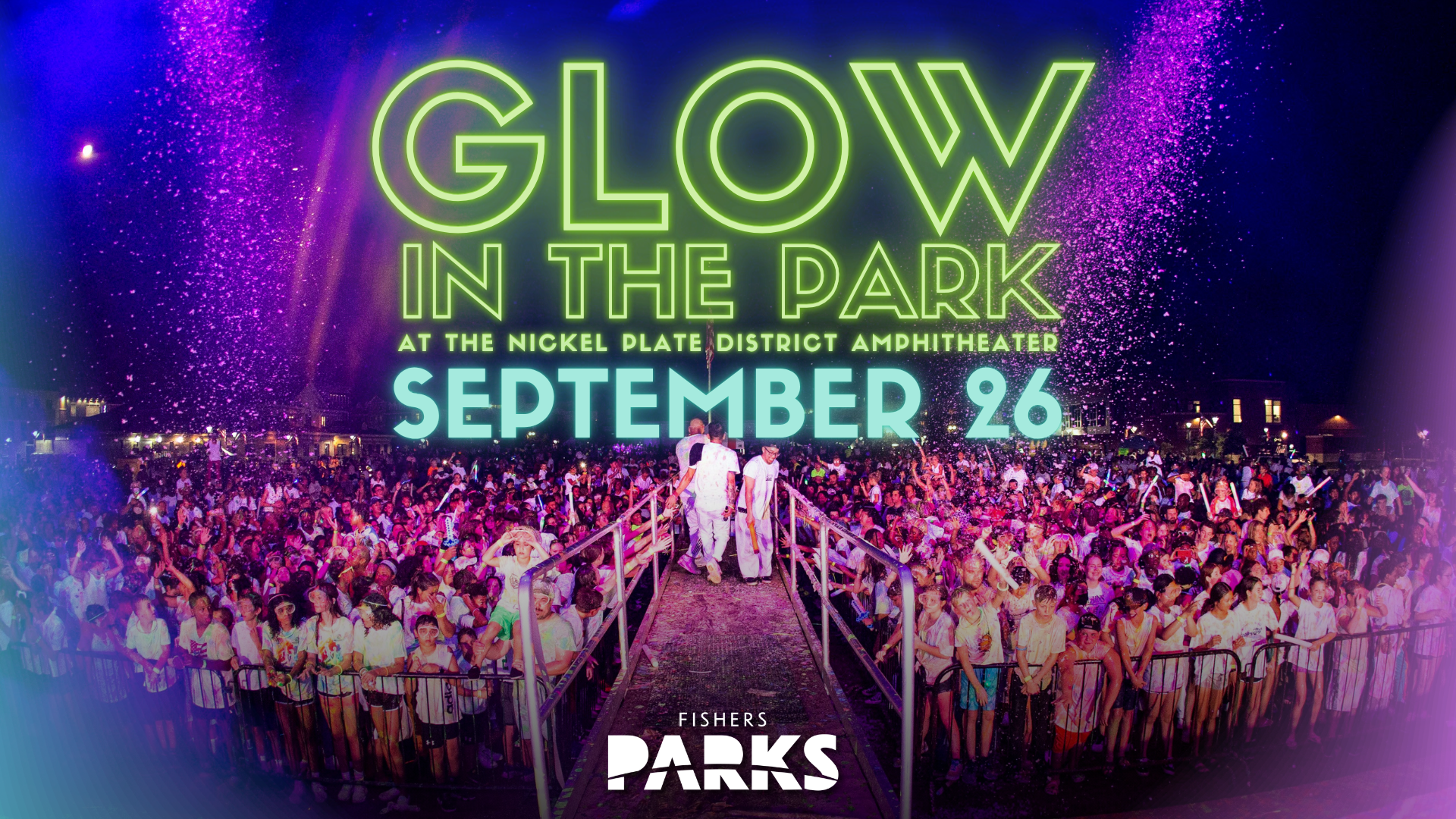 Nighttime crowd at a neon-lit glow-in-the-park event with confetti and a raised walkway, large neon text reading 'GLOW IN THE PARK' and date 'SEPTEMBER 26'